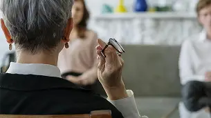 The back of a woman's head as she holds a meeting